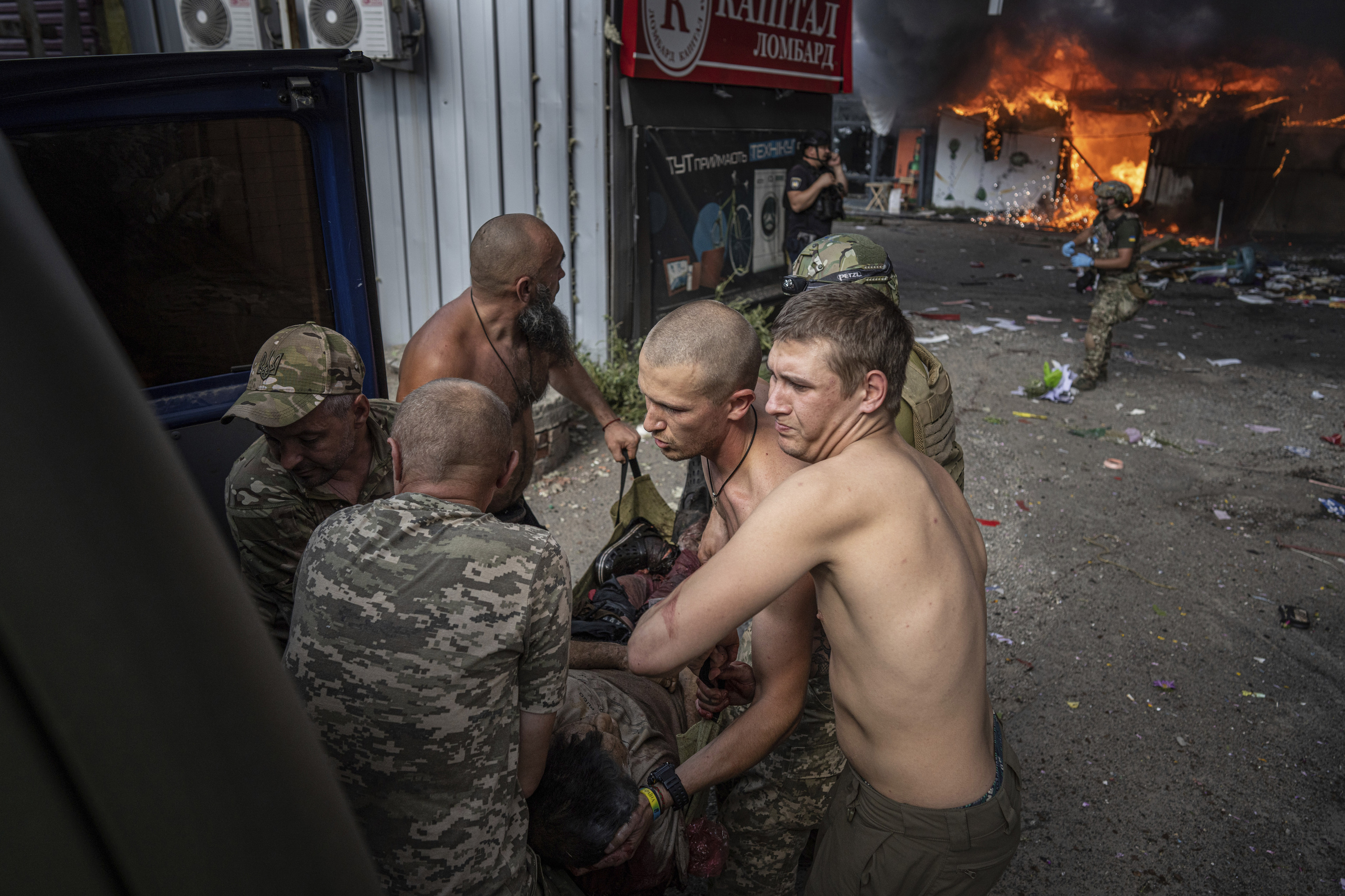 Soldados ucranianos cargan a una mujer herida tras un ataque ruso a un mercado en Kostiantynivka.