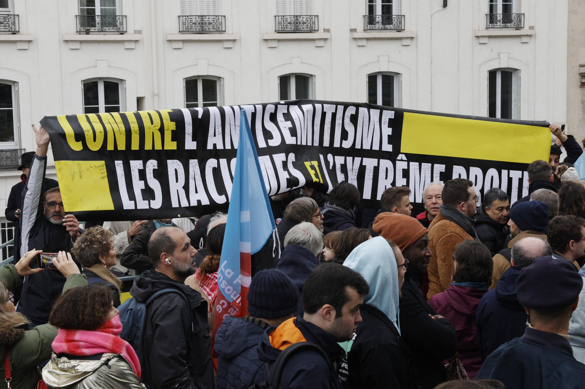 Los partidarios del LFI blanden una pancarta que proclama: "Contra el antisemitismo, el racismo y la extrema derecha" cerca del monumento que marca el rodeo de Vél' d'Hiv.