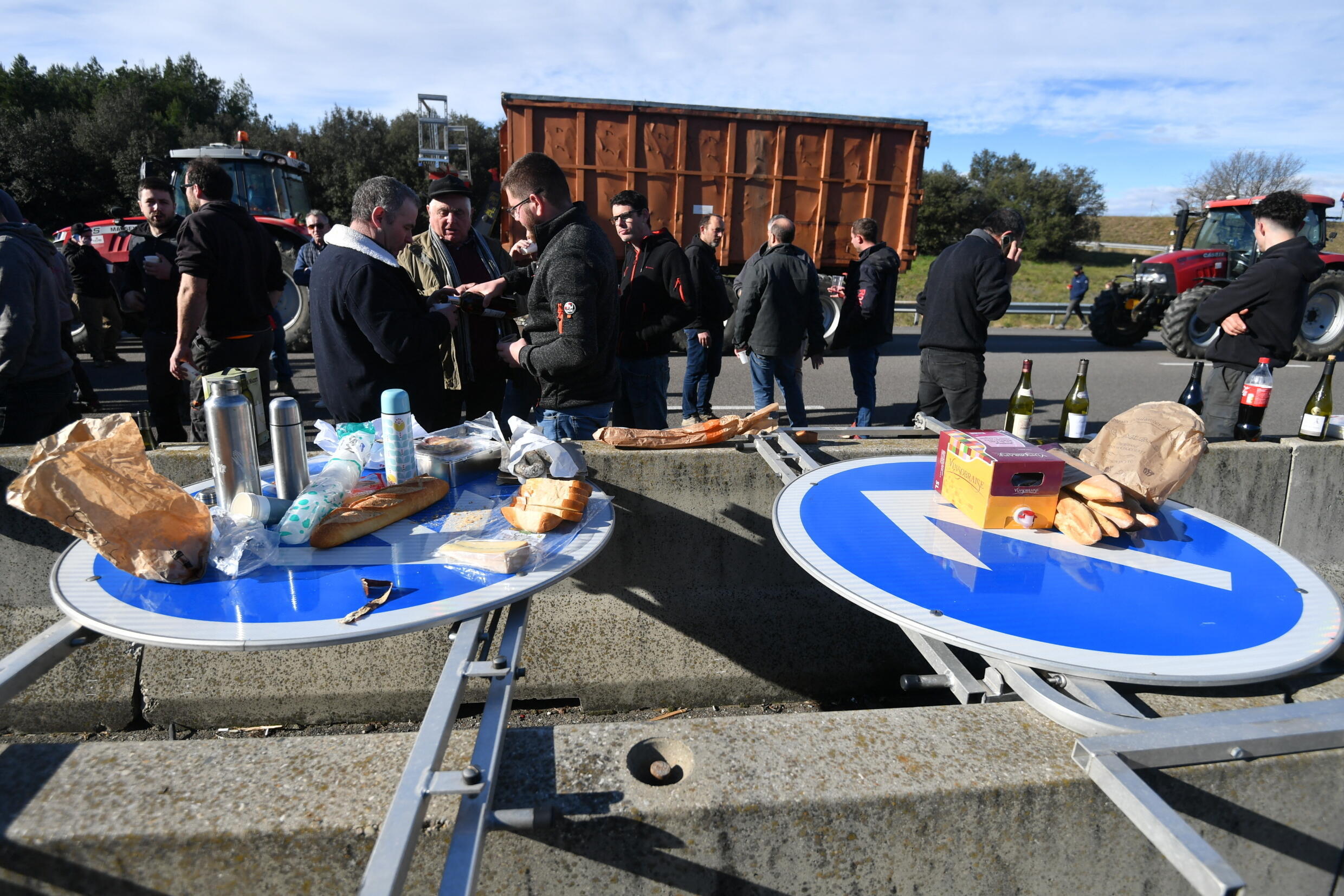 Los agricultores interrumpen su protesta para almorzar usando señales de tráfico como mesas en la autopista A7 en el sureste de Francia el 24 de enero de 2024.
