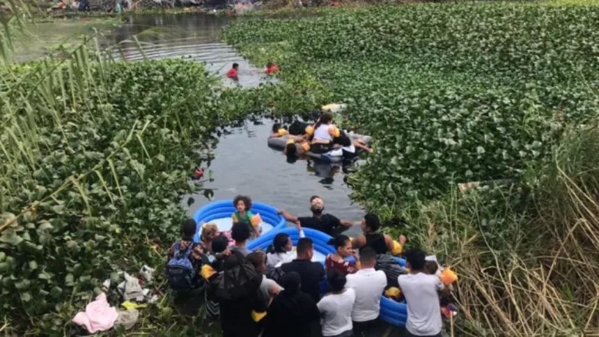 Migrantes venezolanos cruzan el Río Grande con sus hijos en un colchón inflable