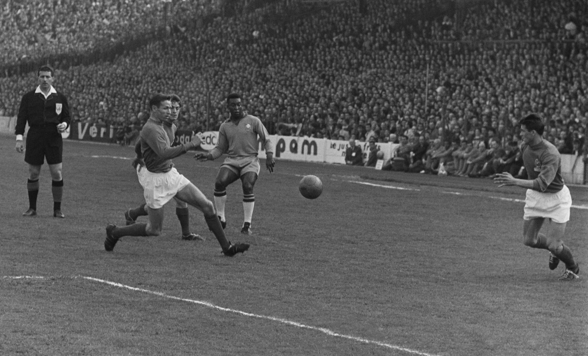 El futbolista brasileño Pelé, en el centro, está rodeado por tres jugadores franceses el 28 de abril de 1963 en Colombes.  Pelé anotó los 3 goles de su equipo cuando Brasil venció a Francia 3-2.